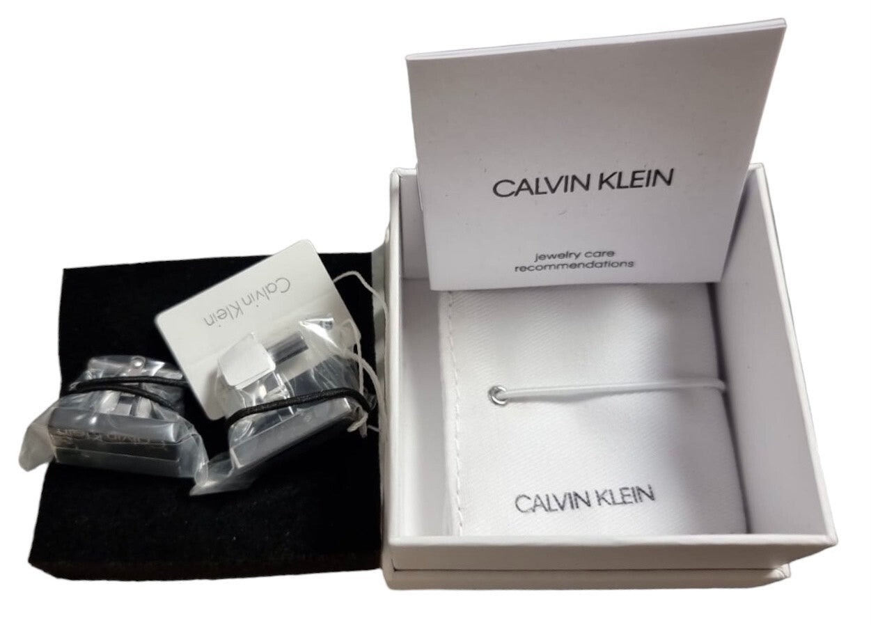 Calvin Klein Boost Manschettenknöpfe für Herren aus Edelstahl in Silber und Schwarz, detailreiche Oberflächenoptik.