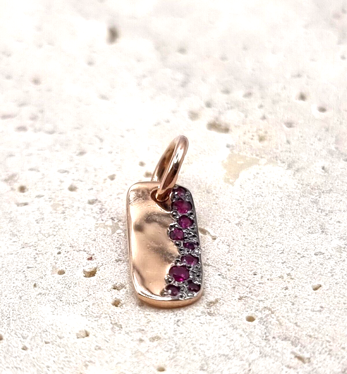 Dodo Charm aus 9 Karat Roségold mit Rubin, elegantes Schmuckstück mit funkelndem Rubinstein in natürlicher Detailaufnahme
